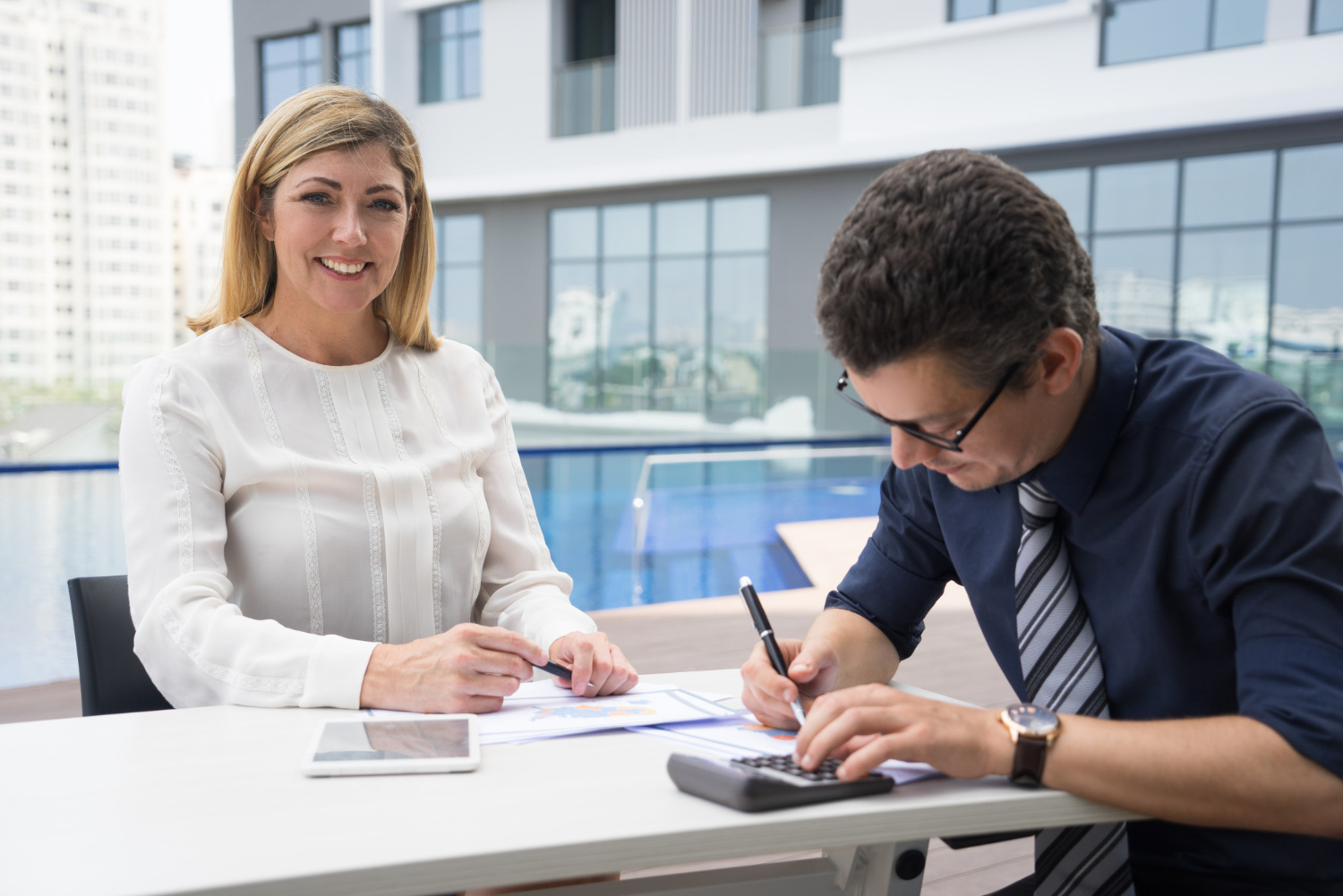Cheerful excited mature female financier smiling while accountant using calculator<br />